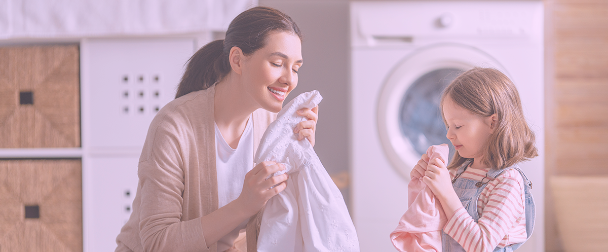 Mulher e menina com roupa num ambiente de lavandaria doméstica