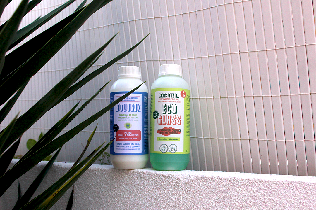 Prevenção de Bolores e Fungos - BOLORIK Dois frascos brancos e verde para produtos, com rótulos distintos, sobre parede branca perto de plantas