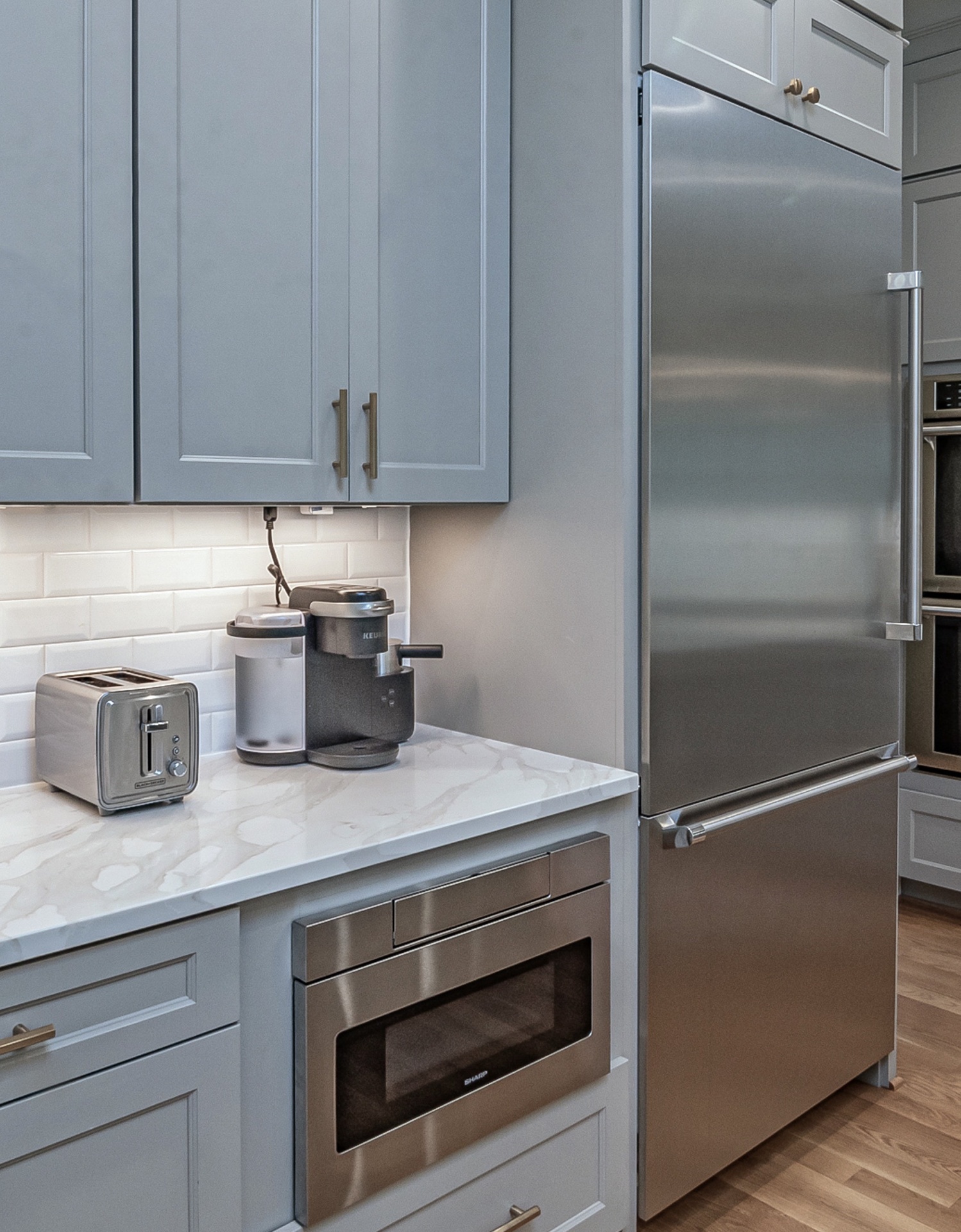 Cozinha moderna com eletrodomésticos em inox e armários cinzentos