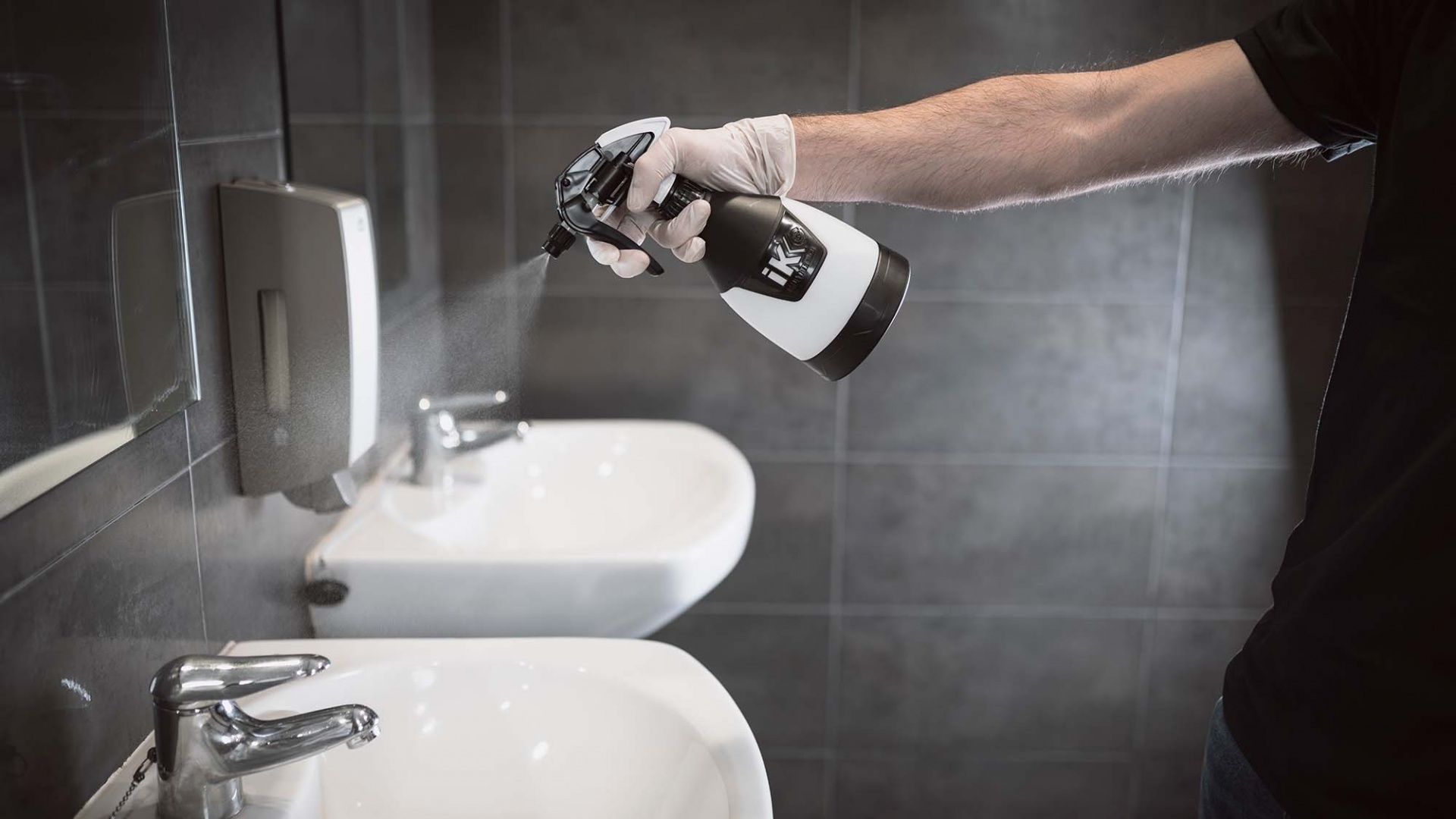 Pulverizador Pul Mini 360°- 500ml Homem a pulverizar líquido num lavatório branco com torneira cromada numa casa de banho