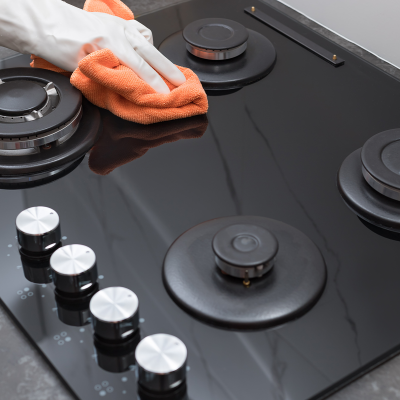 Placa de fogão a gás preta com cinco queimadores e cinco botões prateados