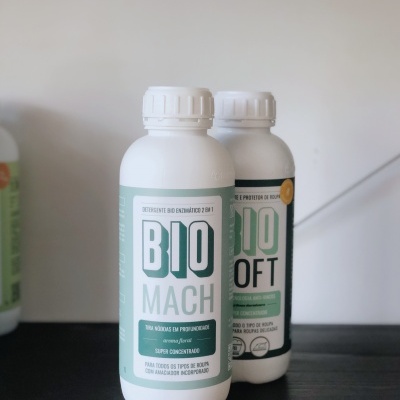 Dois frascos brancos BIO MACH e BIO SOFT em fundo verde claro sobre superfície escura