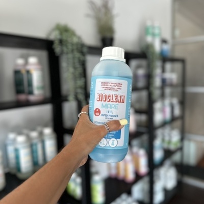 Frasco azul claro do produto DIOLCLEAN MARE segurado por mão