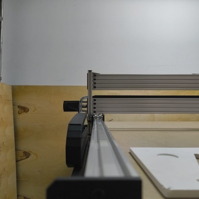 Impressora 3D ou máquina CNC com estrutura metálica prateada e correia preta