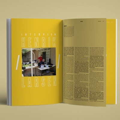 Livro aberto com páginas amarelas e texto, com fotografia de entrevista.