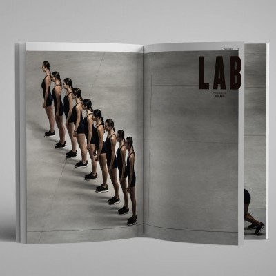 Revista aberta com mulheres alinhadas em fatos de banho pretos e texto LAB na página direita