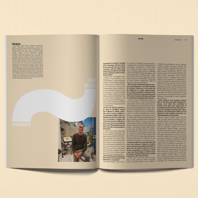 Página dupla de revista aberta com texto, grande ponto de interrogação branco e foto de homem sentado ao ar livre