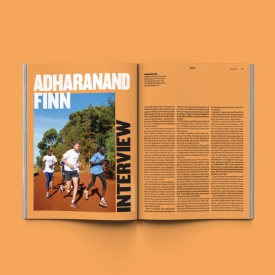 Revista aberta com entrevista a Adharanand Finn, foto de corredores numa pista de terra e texto em colunas.