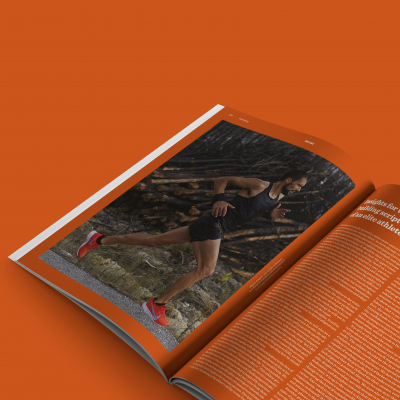 Revista aberta com imagem de homem a correr e texto sobre fundo laranja
