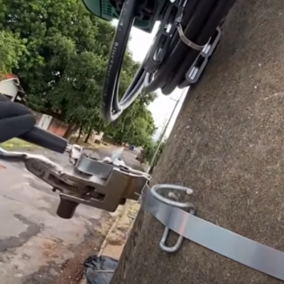 Ferramenta elétrica a cortar braçadeira metálica num poste de concreto