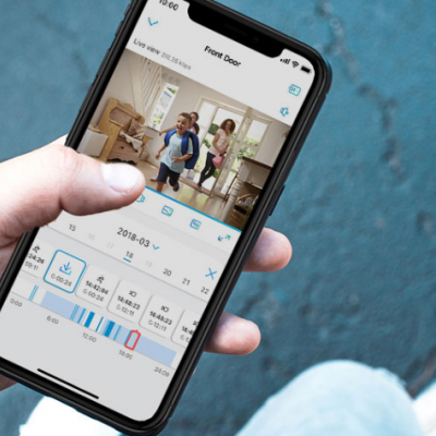 Pessoa segurando smartphone com aplicação aberta mostrando família numa sala