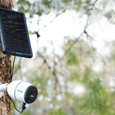 Câmara de segurança branca com painel solar montada em árvore