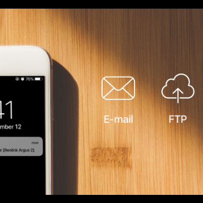 Telemóvel branco com ecrã ligado e ícones de aplicações sobre fundo de madeira clara.