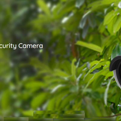 Câmara de segurança WiFi branca montada numa parede com fundo de plantas verdes