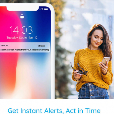 Smartphone com notificação de alarme e mulher a usar telemóvel ao ar livre