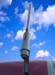 Antena branca montada num veículo com céu azul atrás