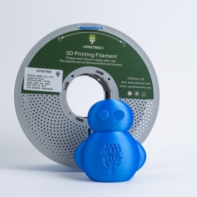 Rolo de filamento 3D cinza com boneco azul decorativo em fundo branco