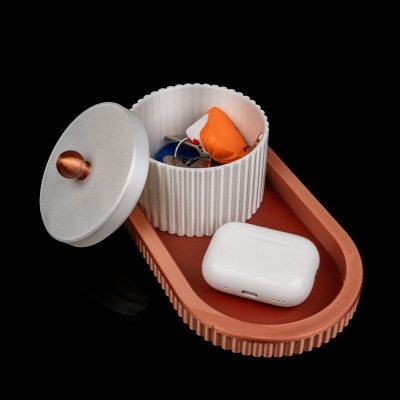 Caixa de armazenamento branca com tampa cinzenta sobre bandeja castanha contendo objetos pequenos e estojo branco para earbuds