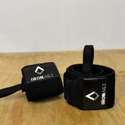Faixas de suporte de pulso pretas com logo 'IRON AGE' em superfície de madeira