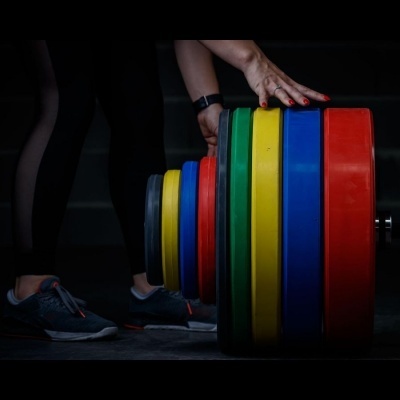 Placas coloridas para levantamento de peso empilhadas num ambiente escuro