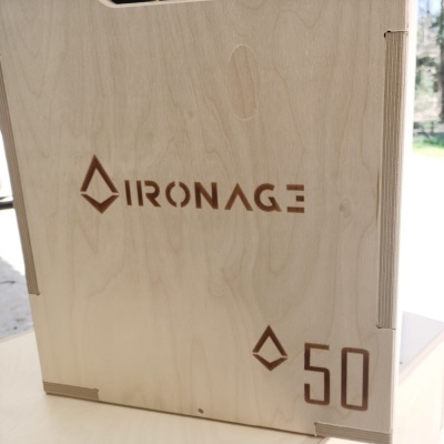 Caixa de madeira clara com gravação IRONAGE e número 50