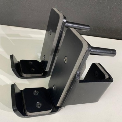 Suportes metálicos pretos com base almofadada cinzenta sobre superfície branca