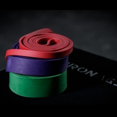 Três bandas elásticas coloridas empilhadas sobre superfície escura