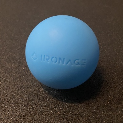 Bola azul com a inscrição IRONAGE em relevo sobre superfície preta texturada