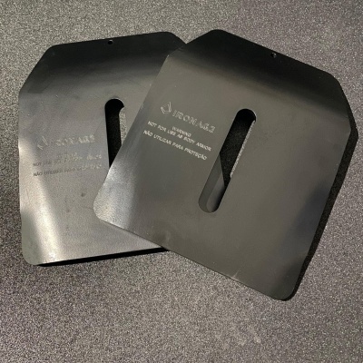 Duas placas balísticas pretas com texto branco sobre uma superfície cinza.