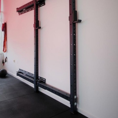 Estrutura de treino preta em parede com chão de tapete preto