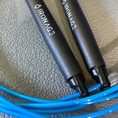 Corda de saltar com cabos pretos e corda azul sobre fundo cinza