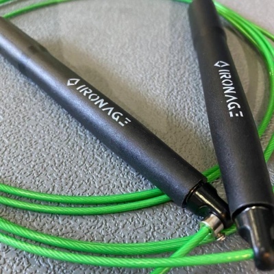 Corda de saltar preta e verde com marca IRONAGE em fundo cinzento.