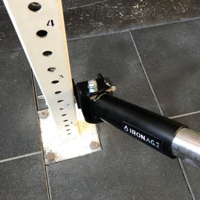 Suporte metálico branco com tubo preto 'IRONAGE' preso ao chão de azulejos escuros