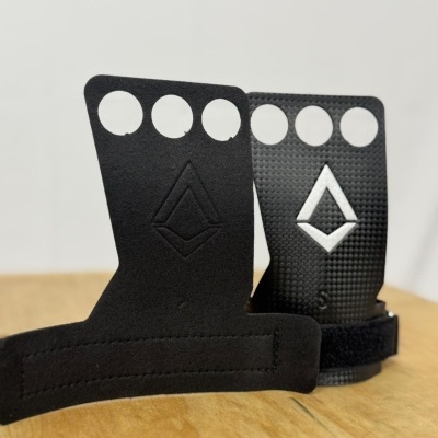 Par de suportes pretos para mãos com quatro orifícios e símbolo geométrico em relevo