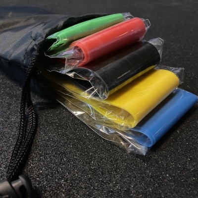 Faixas elásticas coloridas para exercício em saco preto sobre superfície preta