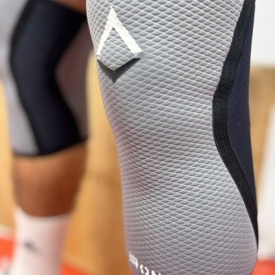 Jelheira elástica cinza com textura colmeia e detalhes pretos e brancos no joelho.