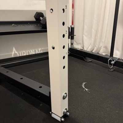 Estrutura metálica de equipamento de ginásio com marcações numéricas e pavimento preto