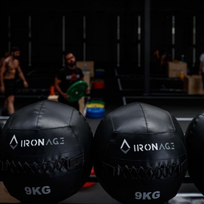 Bolas medicinais pretas de 9KG com a marca IRONAGE numa academia