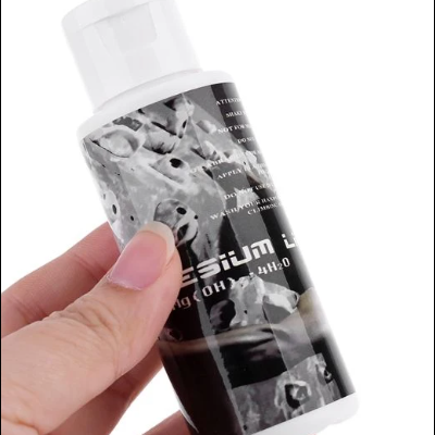 Frasco pequeno branco com rótulo preto e texto 'CESIUM', segurado por uma mão