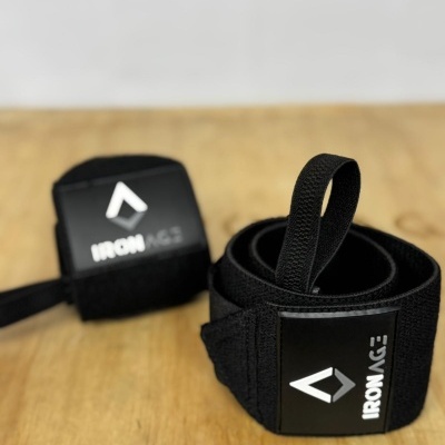 Tiras de suporte para pulso negras com etiquetas IRON AGE sobre mesa de madeira