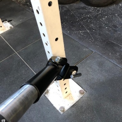 Suporte ajustável de metal preto em poste branco em ginásio