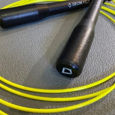 Corda de saltar com cabos pretos e corda amarela em fundo cinza