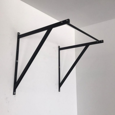 Estrutura metálica preta com barras diagonais na parede branca