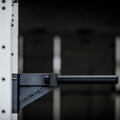 Barra de treino preta fixada a estrutura metálica branca com texto IRONAGE