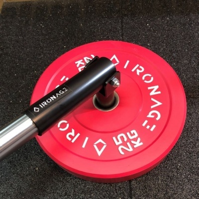 Disco de peso vermelho 25 KG com barra preta e metálica sobre pavimento preto