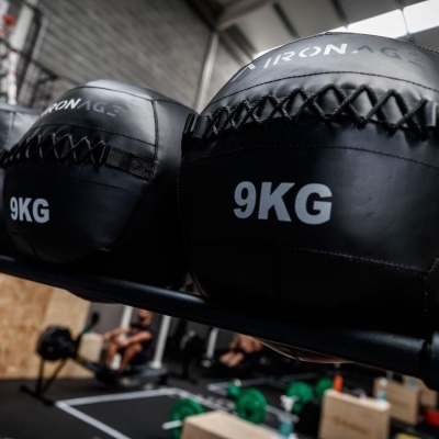 Bolas medicinais pretas de 9KG com texto IRON AGE num ginásio