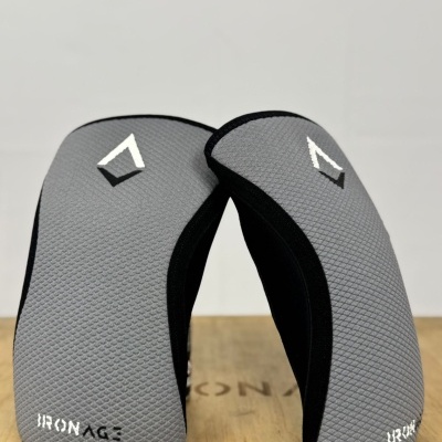 Peças cinzentas texturizadas com bordas pretas e texto IRON AGE