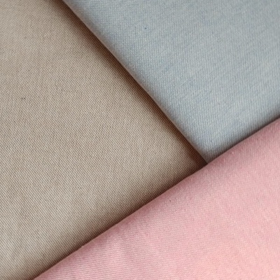 Três tecidos lisos bege, azul claro e cor-de-rosa com textura diagonal