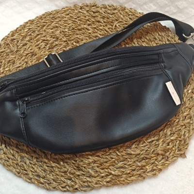 Bolsa preta tipo cinto com dois fechos sobre suporte redondo trançado