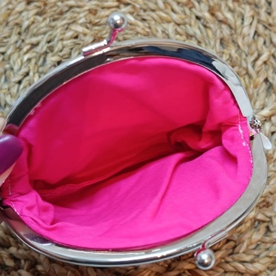 Pequena bolsa com fecho metálico e interior rosa